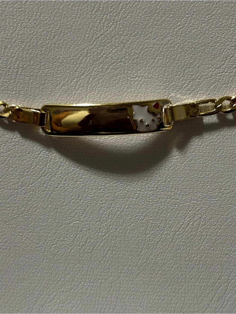Gold-tone Hello Kitty Accent ID Bracelet. Laminated gold. Everyday use.
